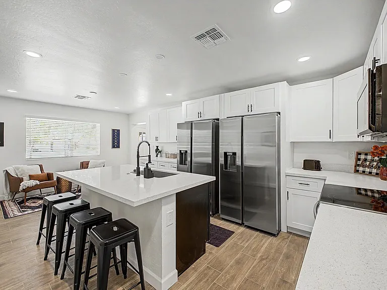 Spacious kitchen with large island seating, ample cabinetry, and stainless steel appliances, open to the dining area.