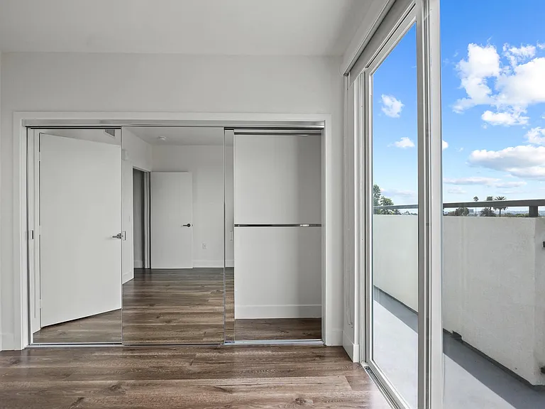 Bedroom with Mirrored Closet, Vinyl flooring, and Balcony with Skyline Views