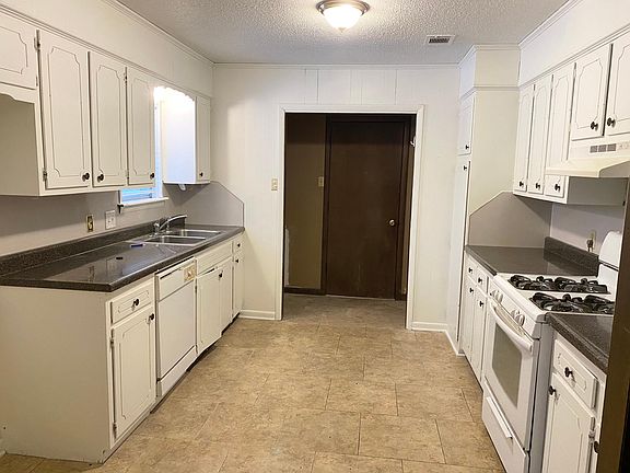 Kitchen looking toward the garage door. The washer and dryer connections are in the space between the kitchen and garage.