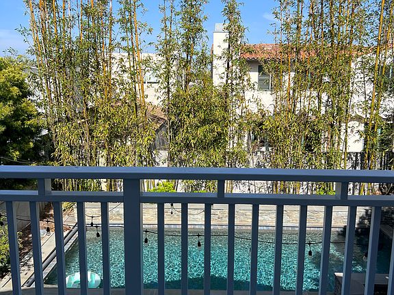 Deck off primary bedroom overlooking backyard and pool