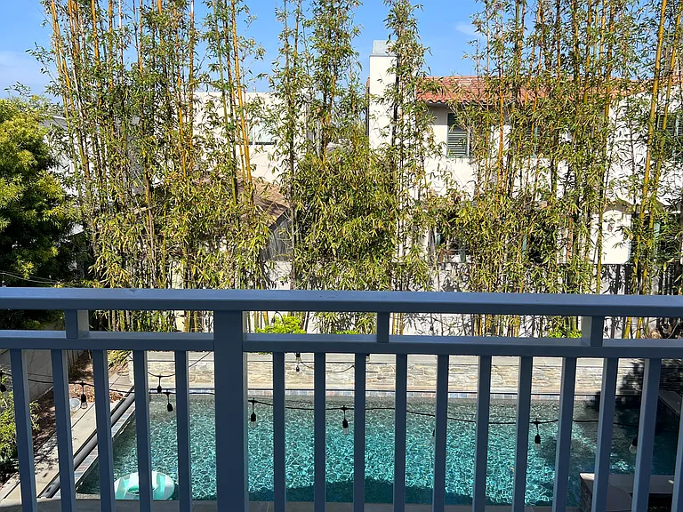 Deck off primary bedroom overlooking backyard and pool