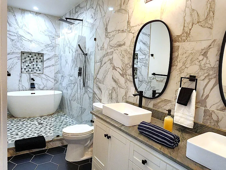 A beautiful, luxurious bathroom featuring a modern bathtub and dual modern sinks, offering a spa-like experience
