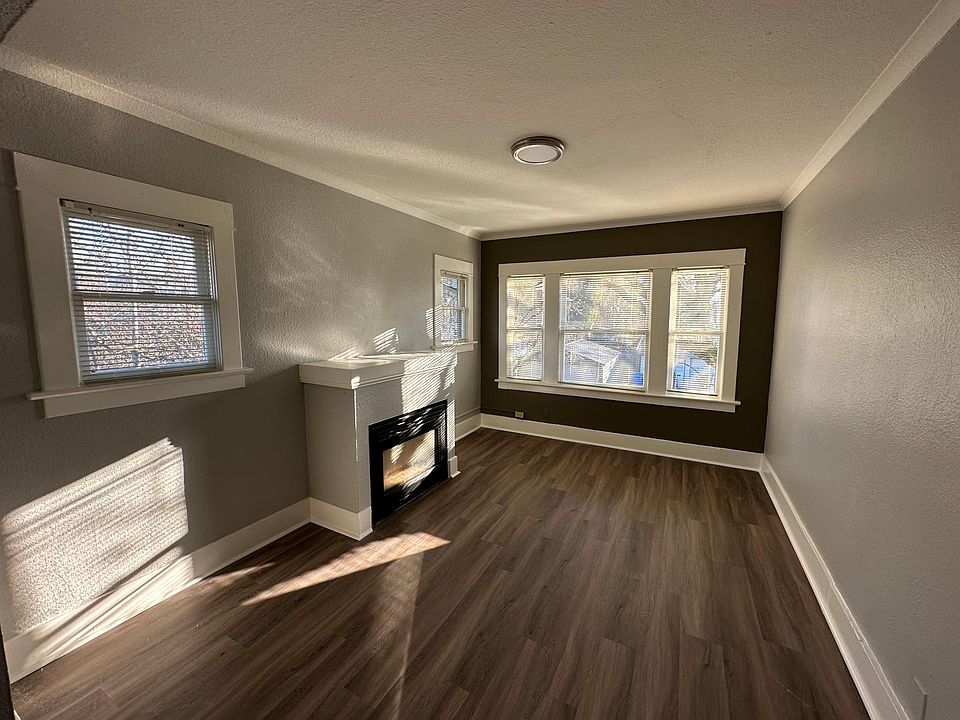 Living room with lots of natural light, a soothing view of tree tops, and a gas fireplace.