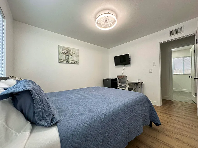 Modern room with exclusive full bathroom next to room.