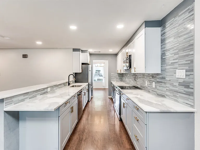 Modern galley kitchen featuring light wood-finish flooring