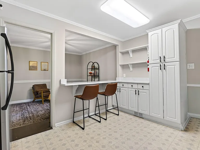 Kitchen with peninsula breakfast bar, ample cabinetry, and open pass-through to adjacent living area for easy dining.