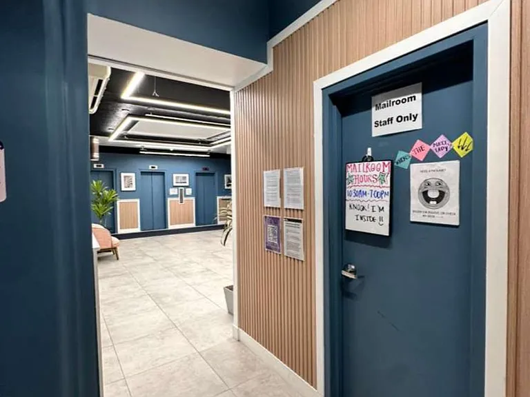 Well-lit interior corridor with tiled flooring and access to shared building amenities and offices.