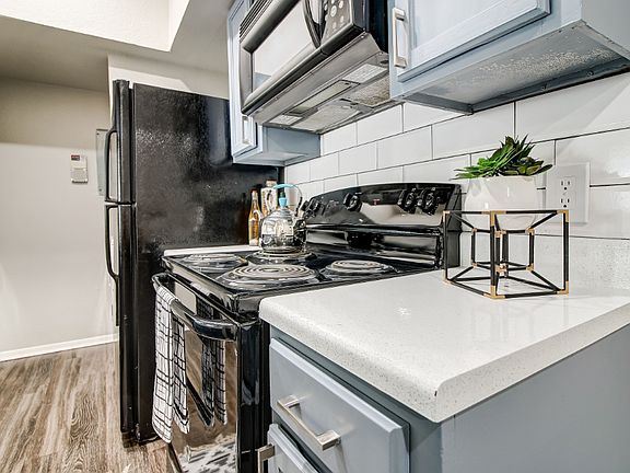 Model kitchen with gray cabinets and gas stove