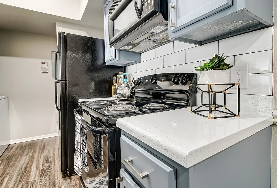 Model kitchen with gray cabinets and gas stove