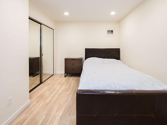 Bedroom alcove shown with queen bed and night stand - unit comes unfurnished