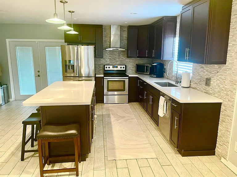 Large kitchen featuring large island. Will include basic cooking and eating tools, and 5 stools for around the bar area.