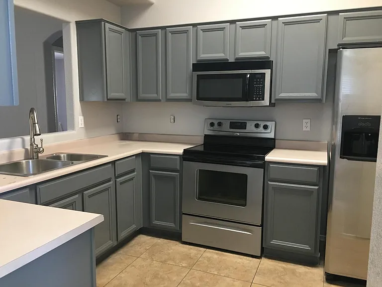 The kitchen features newly-painted cabinets, a new sink and stainless steel appliances.