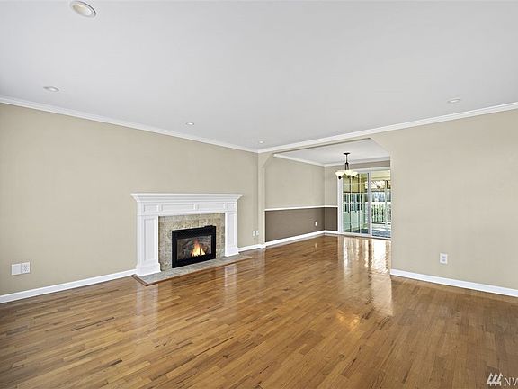 Gas fireplace with mantle, leading into dining room.