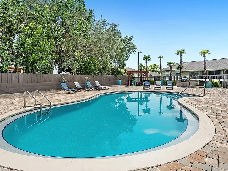 Recline on poolside loungers, basking in the Florida sun amidst the tranquil and opulent pool setting.