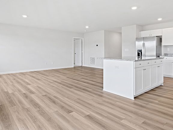 Island kitchen overlooking family room in a DRB Homes Edgewood plan at The Village of College Park c