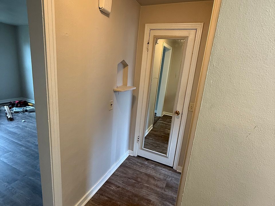 Hallway to bathroom, extra closet space behind mirrored door