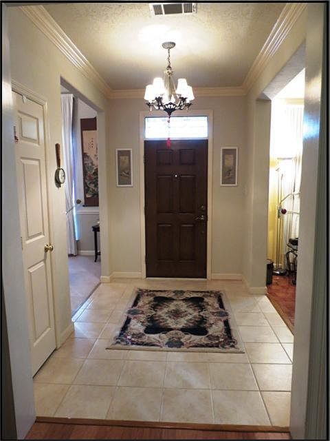 ENTRY WITH TILE FLOORS AND SOLID WOOD DOOR.