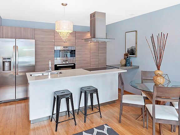 The kitchen features Bosch stainless steel appliances, quartz counters, modern pantry depth cabinets