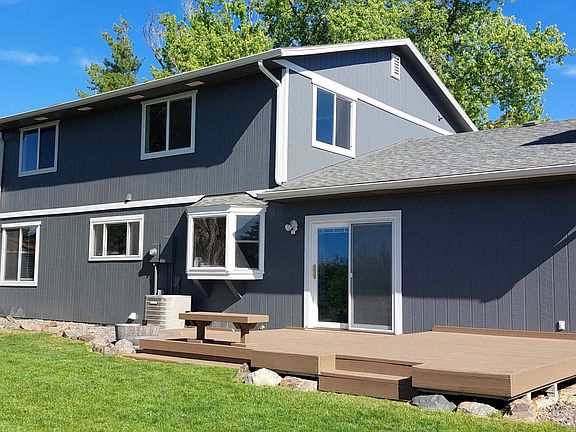 Backyard with deck. Home has central air and ceiling fans for cooling. Side yard leads to garage side door.