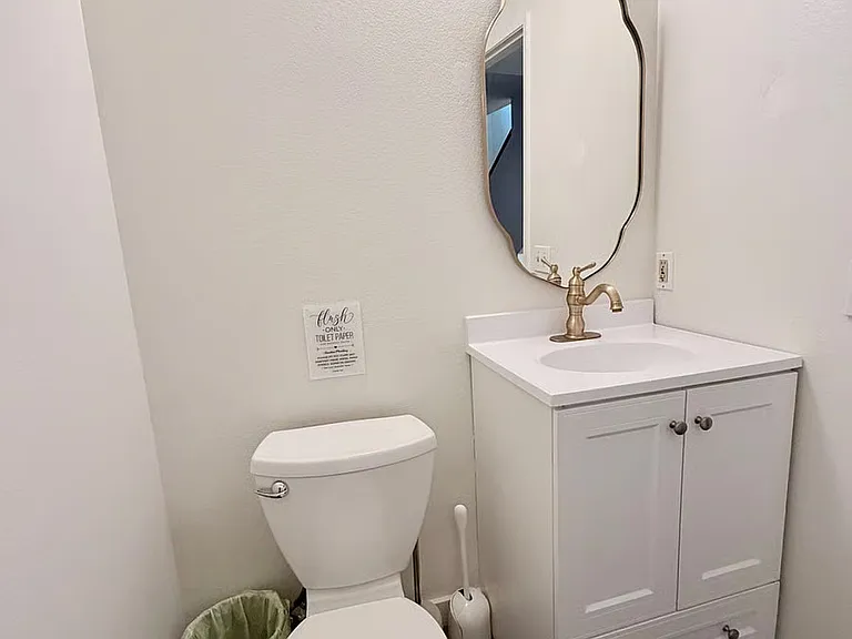 Third bathroom. Half bathroom downstairs with modern fixtures and clean, simple design.