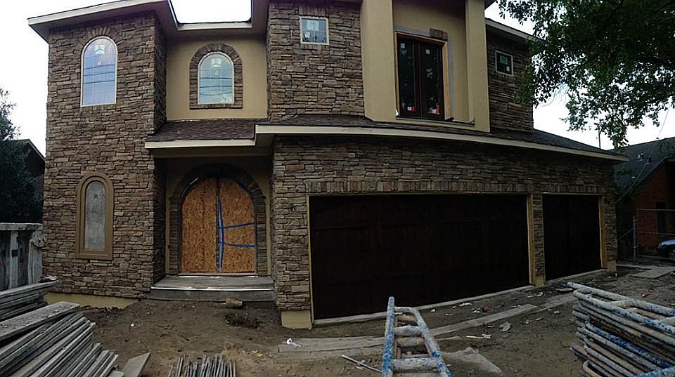 Front Elevation with Cedar Garage Doors installed. Stucco with stone.