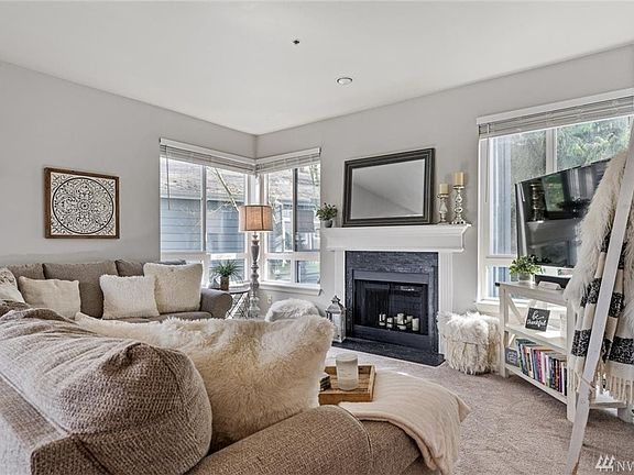 Living room with large windows and cozy fireplace.