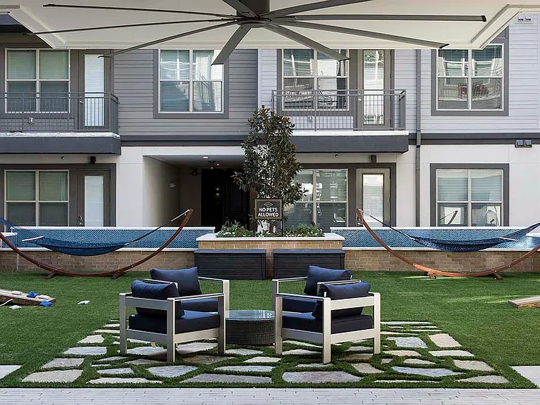 Outdoor lounge with hammocks, water features, and outdoor seating.