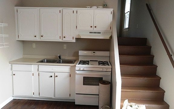 Kitchen with stairs going up to large living room and master