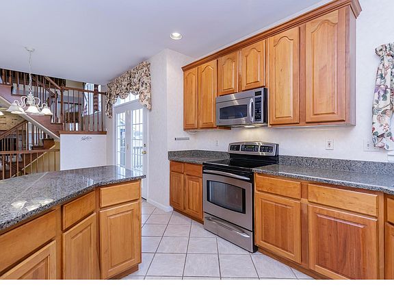 Kitchen with 42 inch cabinets with crown molding, granite counter tops, ceramic title and stainless appliances