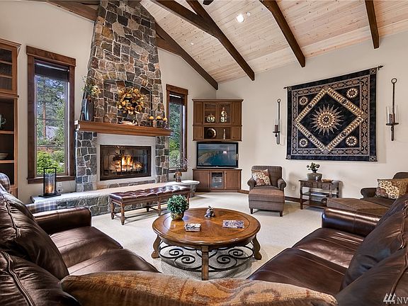Great Room Featuring Elegant Stone Chimney and Hearth, Vaulted, Beam Ceilings.