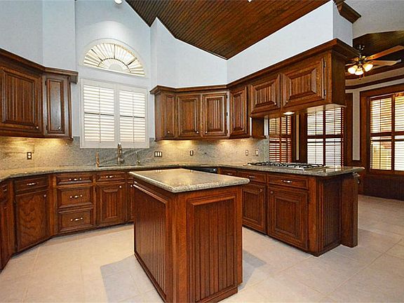 TONS OF STORAGE WITH BEADBOARD DETAIL ON CABINET DOORS, UNDER CABINET LIGHTING & TILE FLOORING (PROF