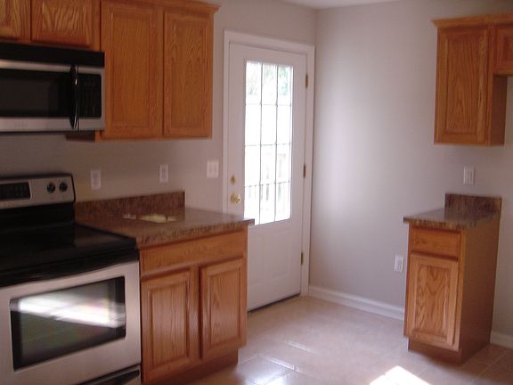 Another view of kitchen showing door to back yard with deck.