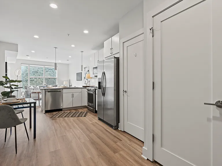 View from unit entrance with pantry and washer/dryer closet doors on right