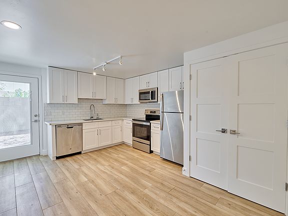 Kitchen with updated appliances and door to backyard