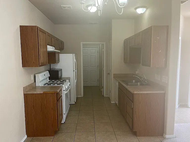 Kitchen including oven, vent hood and fridge