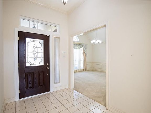 Inside you find this entry with crown molding, a chandelier and low-maintenance tile floors.
