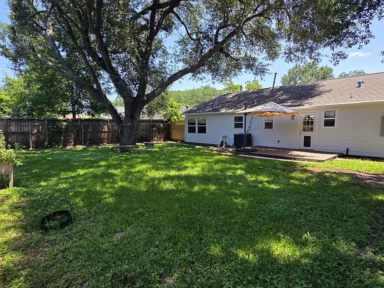 Huge backyard featuring a trex deck, surrounded by a well-maintained lawn, offering a private and inviting outdoor space.