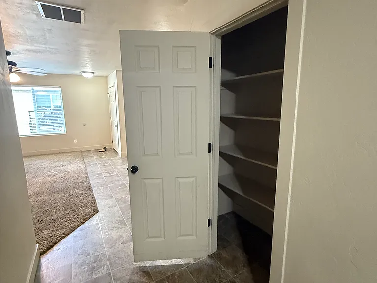 View from kitchen back to front door with pantry door open