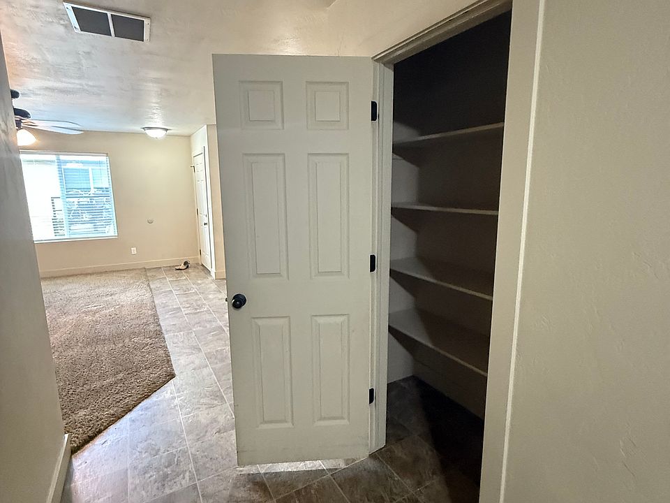 View from kitchen back to front door with pantry door open