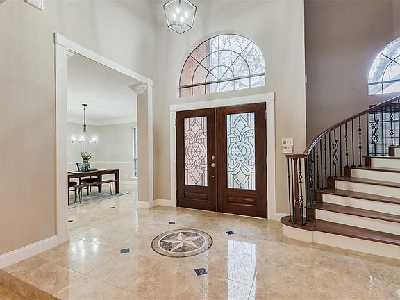 The grand entry boasts attractive wood and glass double doors, a winding staircase and elegant tile that flows throughout the downstairs.
