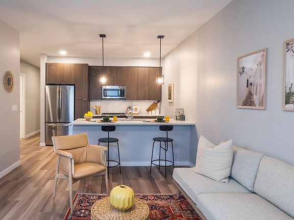 Spacious living room with open concept designer kitchen, espresso cabinetry, and stainless steel appliances.