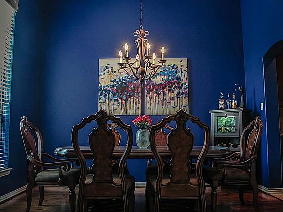 Stunning formal dining room with custom color walls. Right off of kitchen for easy serving.