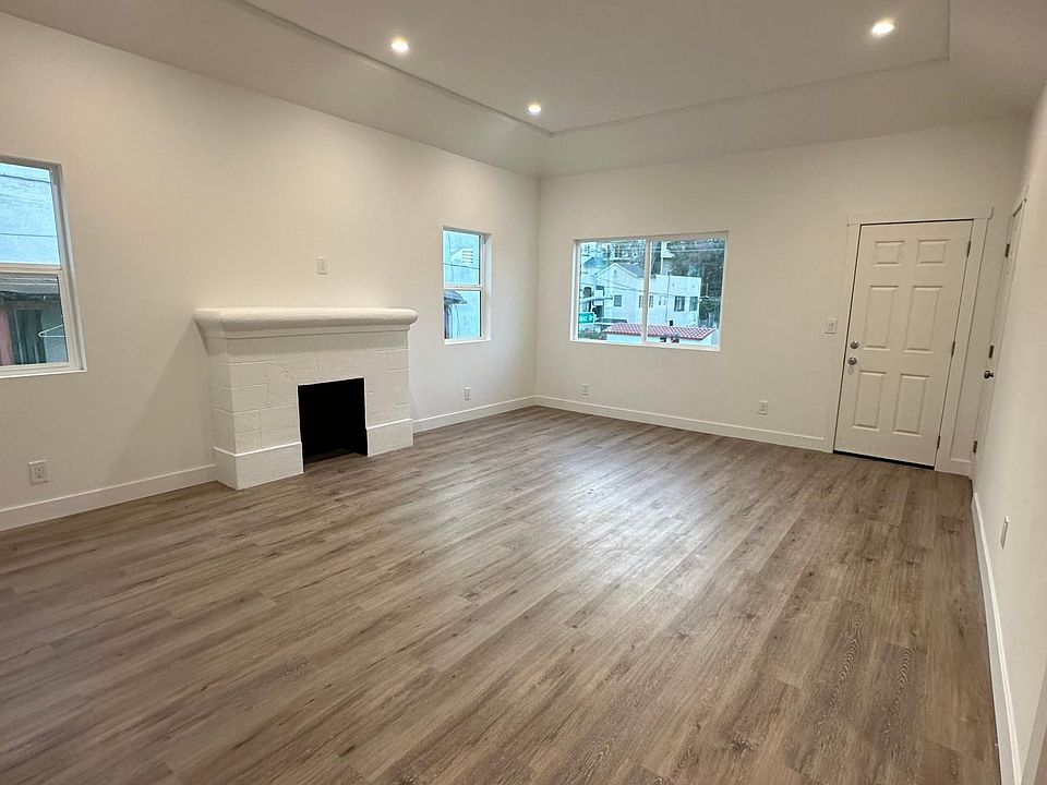 Spacious living room with decorative fireplace and high ceilings.