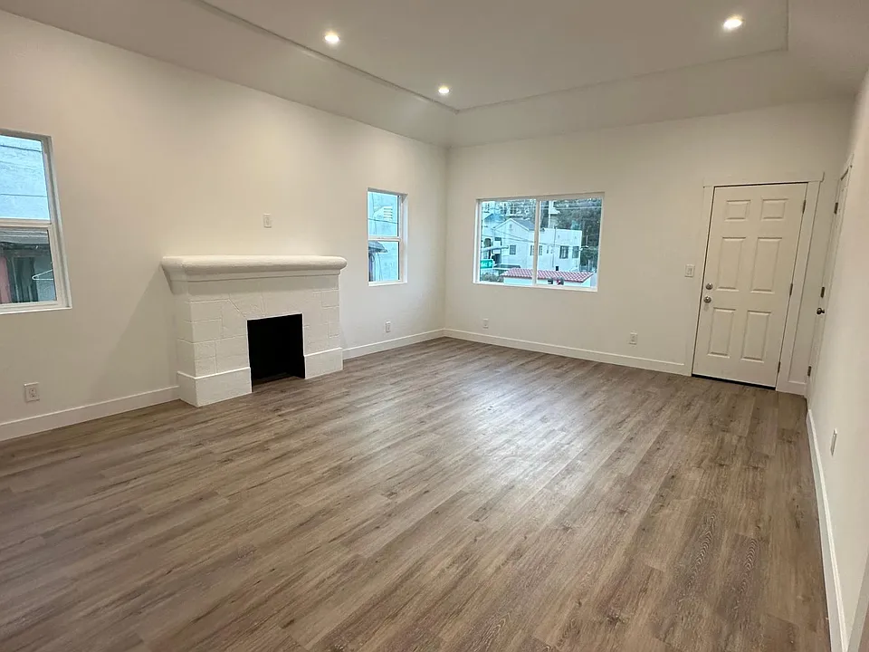 Spacious living room with decorative fireplace and high ceilings.