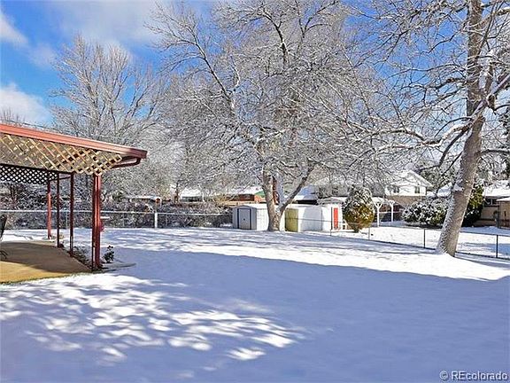 fenced yard with trees, garden shed and covered patio