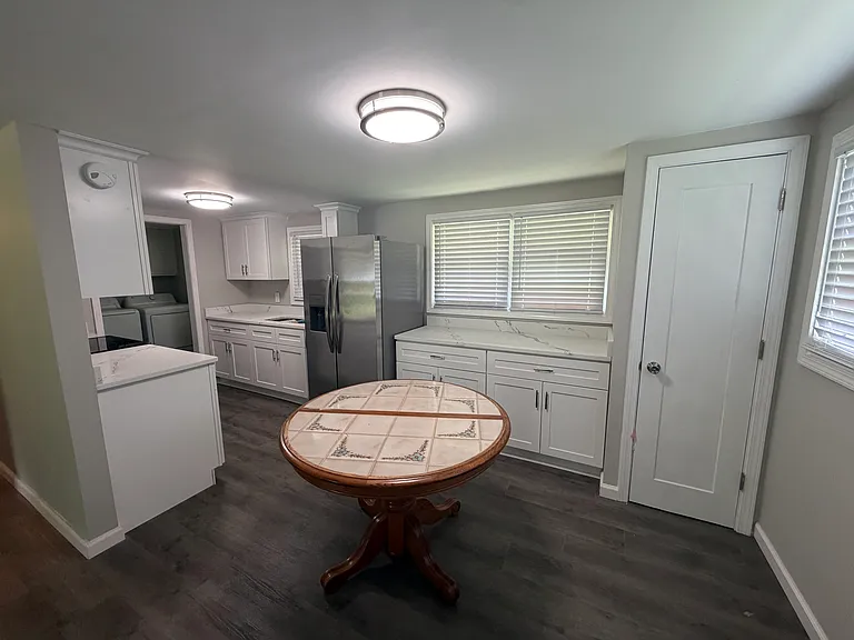 new galley kitchen with new cabinets, marble countertops and pantry.
