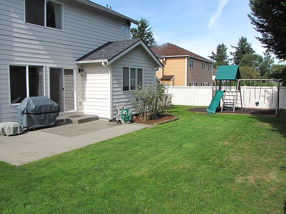 Backyard with patio area, large shed, and raised garden areas