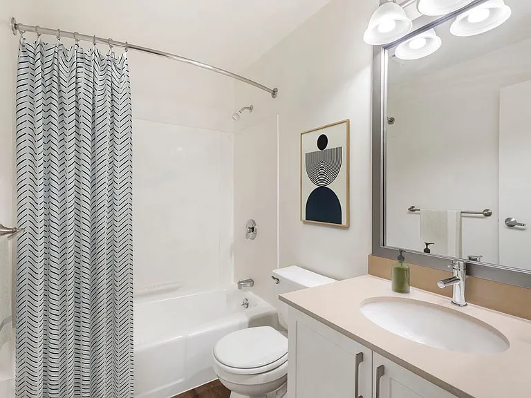 Renovated Package I bath with quartz or granite countertops, white cabinetry, and hard surface flooring
