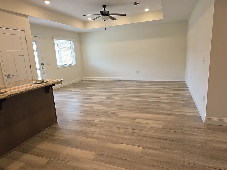 Looking from kitchen into living room with a large picture window for natural light.