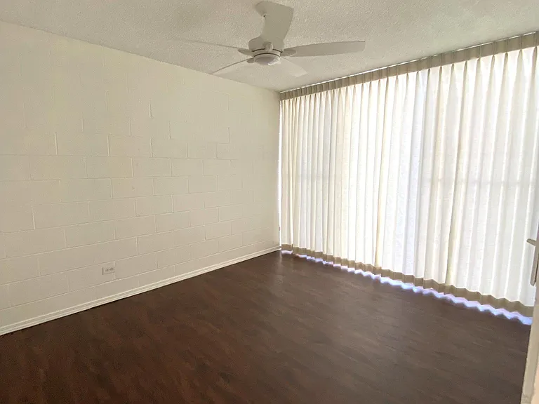 Bedroom facing Anapuni Street with ceiling fan lights and drapes